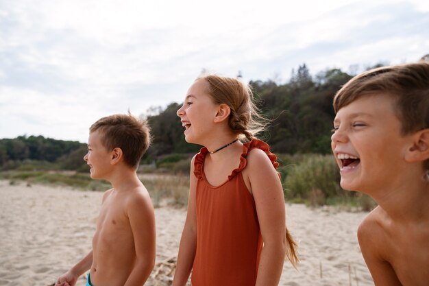 Kostenloses Foto seitenansichtkinder, die spaß am strand haben