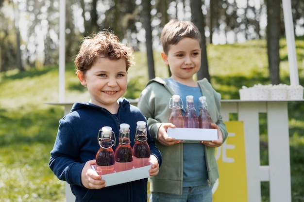 Kostenloses Foto seitenansichtkinder mit limonadenflaschen