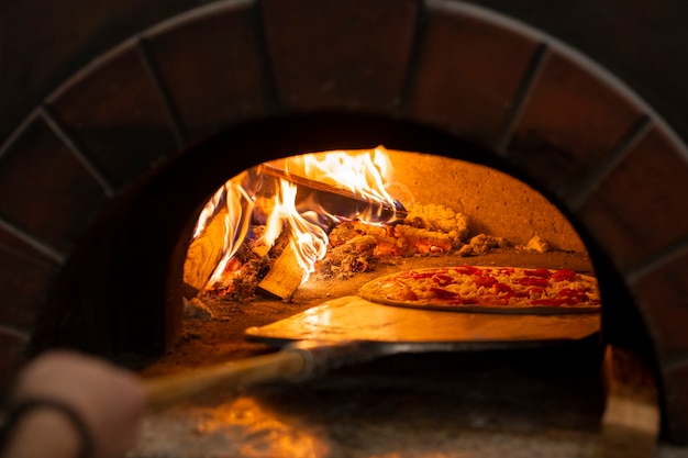 Kostenloses Foto seitenansichtkoch, der köstliche pizza backt