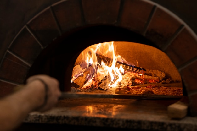 Kostenloses Foto seitenansichtkoch, der köstliche pizza backt