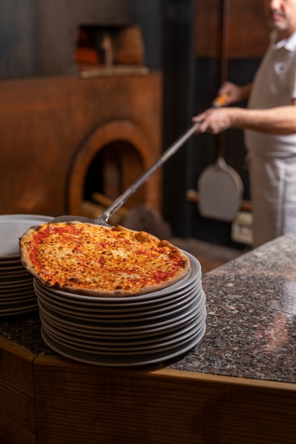 Seitenansichtkoch, der pizza zubereitet