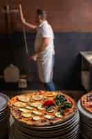 Kostenloses Foto seitenansichtkoch, der pizza zubereitet