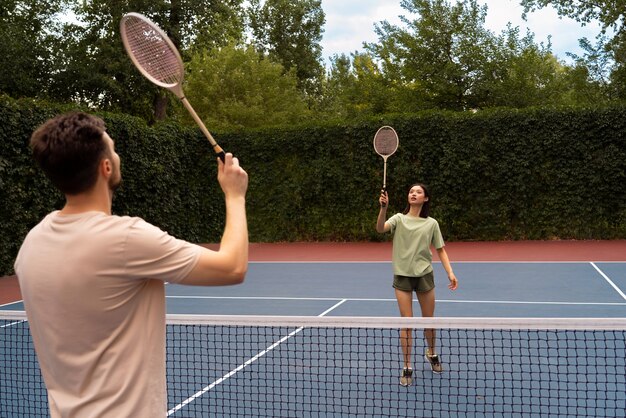 Seitenansichtleute, die Badminton spielen