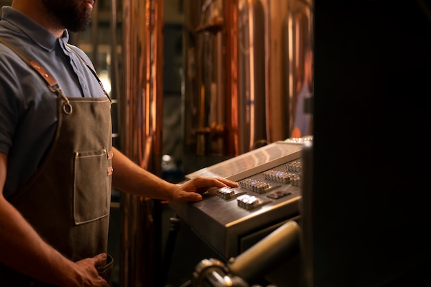 Kostenloses Foto seitenansichtleute, die in der bierfabrik arbeiten