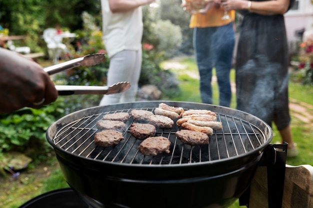 Seitenansichtleute, die nahe Grill plaudern