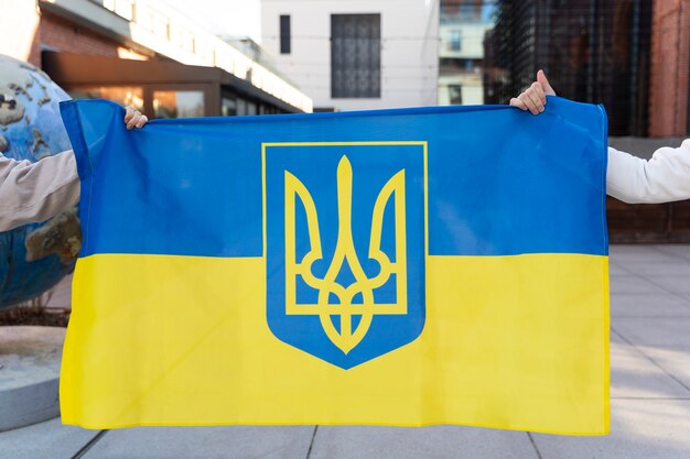 Seitenansichtleute, die ukrainische flagge halten