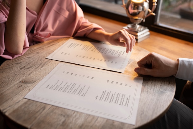 Kostenloses Foto seitenansichtleute mit menüs im restaurant