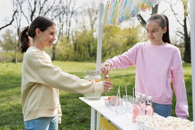 Seitenansichtmädchen, das frische Limonade verkauft