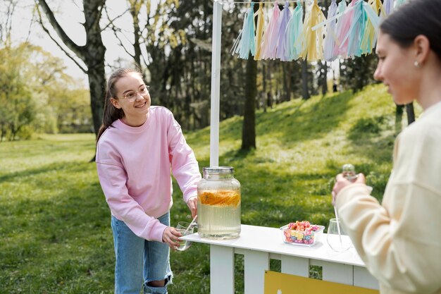 Seitenansichtmädchen, das frische Limonade verkauft