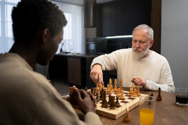 Kostenloses Foto seitenansichtmänner, die drinnen schach spielen