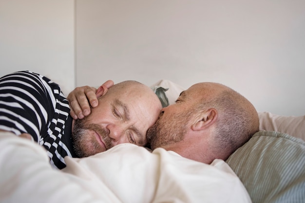 Seitenansichtmänner, die im Bett liegen