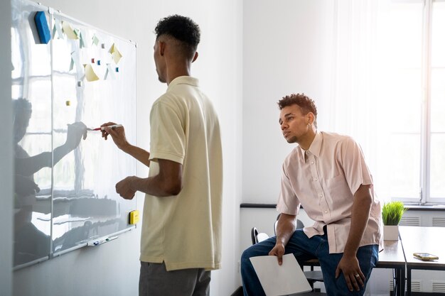 Seitenansichtmann, der auf whiteboard schreibt