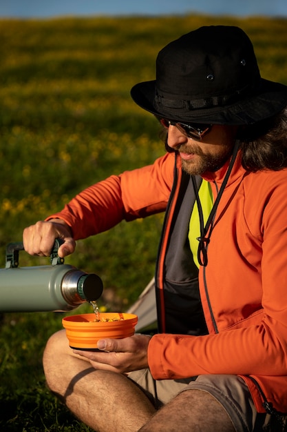 Seitenansichtmann, der Instantsuppe macht