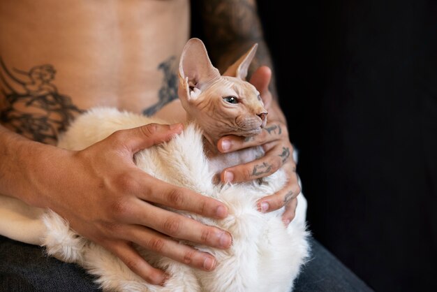 Seitenansichtmann, der nette Katze hält