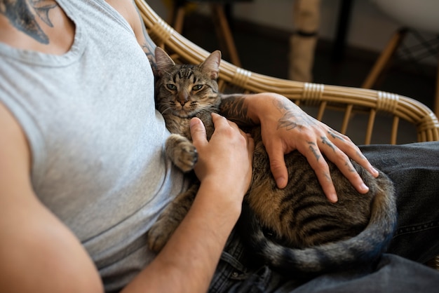 Seitenansichtmann, der nette Katze hält