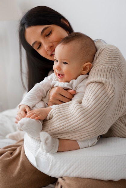 Seitenansichtmutter, die neugeborenes Baby hält