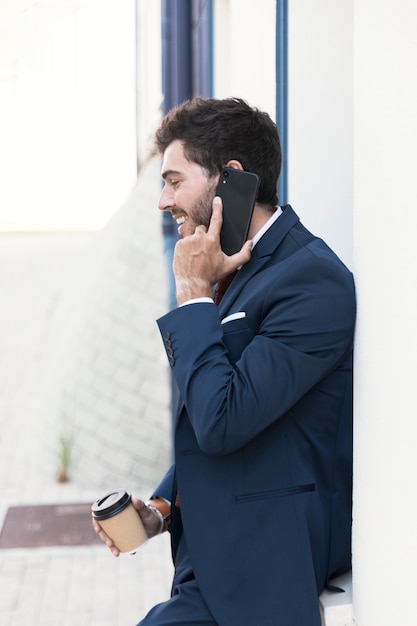 Seitenansichtrechtsanwalt mit Kaffee am Telefon