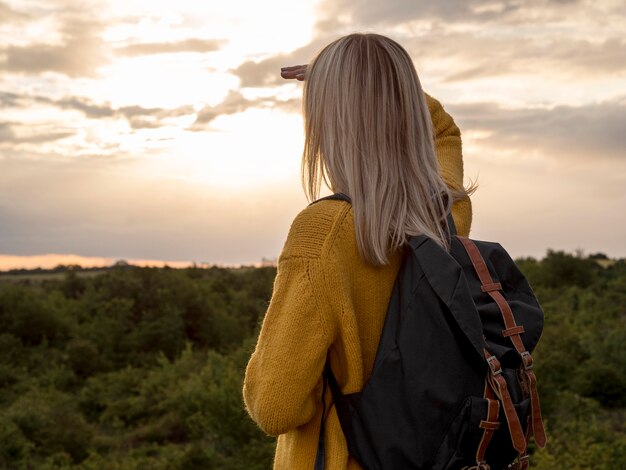 Seitenansichtsfrau bei Sonnenuntergang am Berg