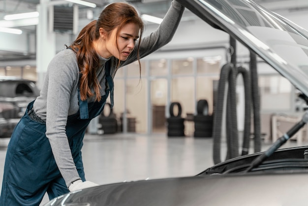 Seitenansichtsfrau, die an einem Autoservice arbeitet