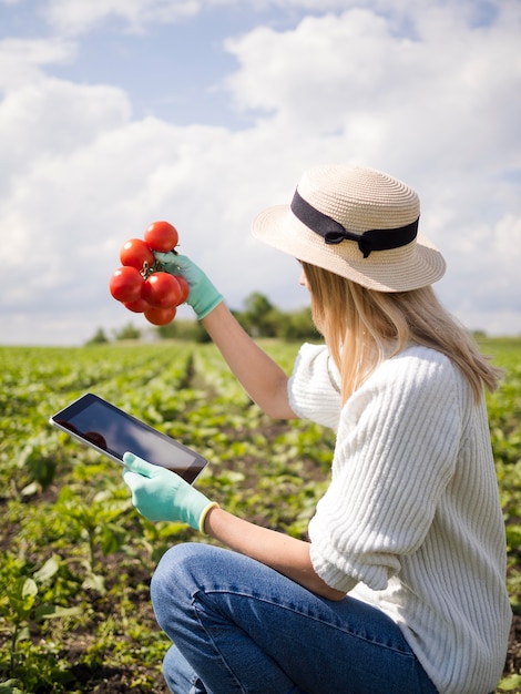 Kostenloses Foto seitenansichtsfrau, die einige tomaten hält