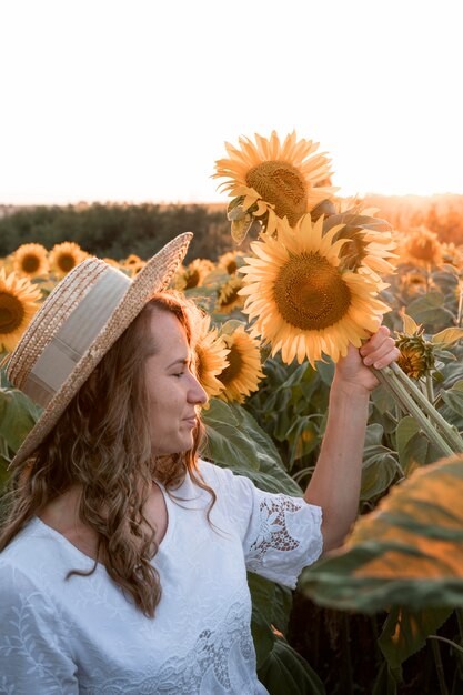 Seitenansichtsfrau, die Sonnenblumen hält