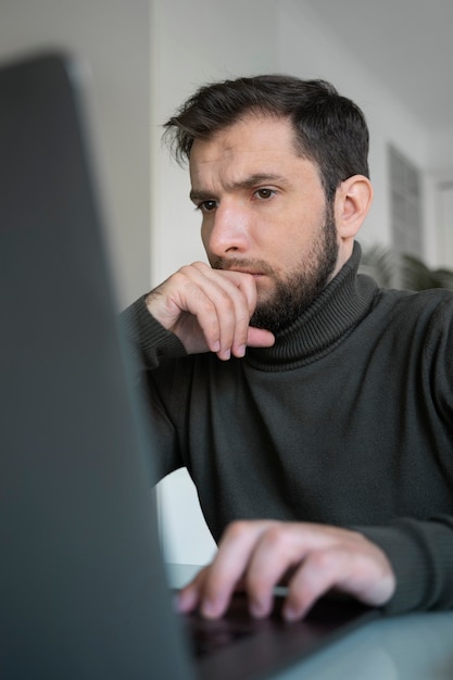 Seitenansichtsmann, der am laptop arbeitet