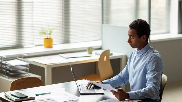 Seitenansichtsmann, der am Laptop arbeitet