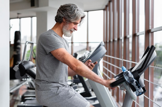 Seitenansichtsmann, der im Fitnessstudio läuft