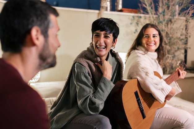 Kostenloses Foto seitenansichtsmileyfrau, welche die gitarre spielt