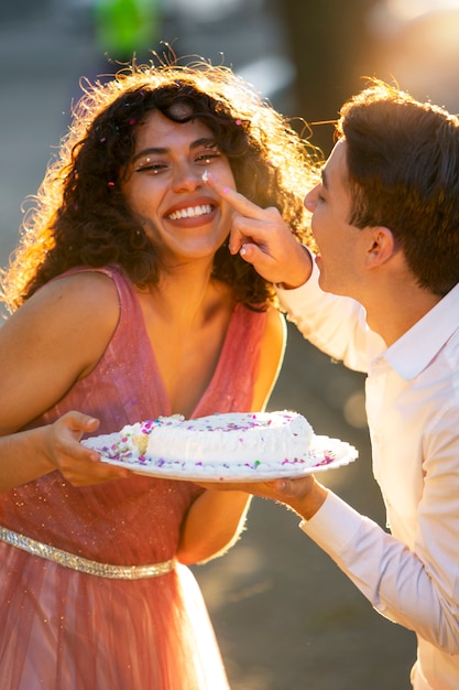 Kostenloses Foto seitenansichtsmileymädchen, das kuchen hält