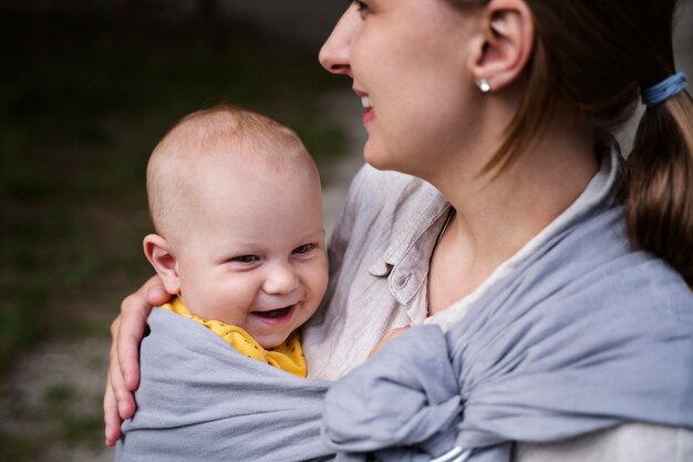 Seitenansichtsmileymutter, die Baby hält