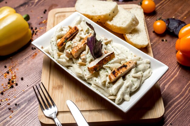 Seitenansichtsnudeln mit Käse und Huhn mit Brotscheiben