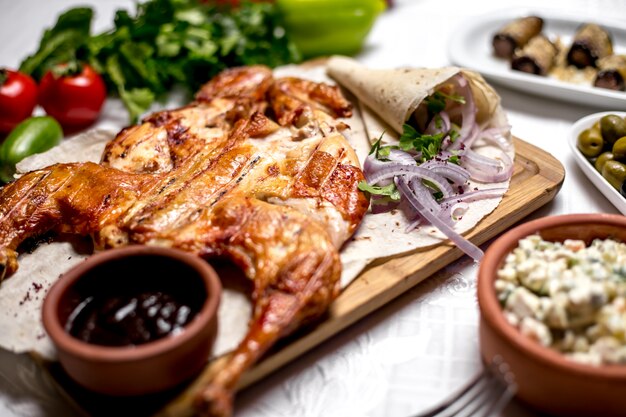 Seitenansichtstabak auf Fladenbrot mit Zwiebeln und Soße mit Salat und Oliven