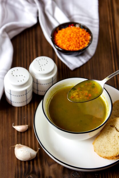 Kostenloses Foto seitenansichtsuppe mit linsen mit brotscheiben mit salz und pfeffer