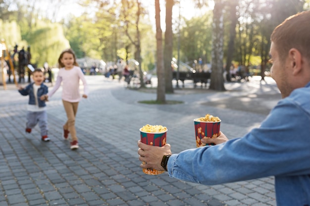 Seitenansichtvater, der Popcorn hält