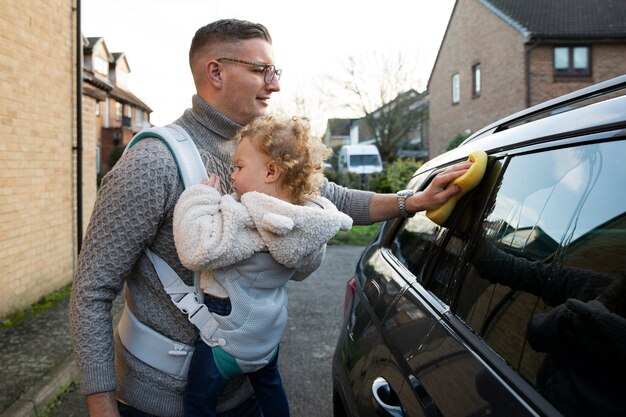 Seitenansichtvater mit waschendem Auto des Babys