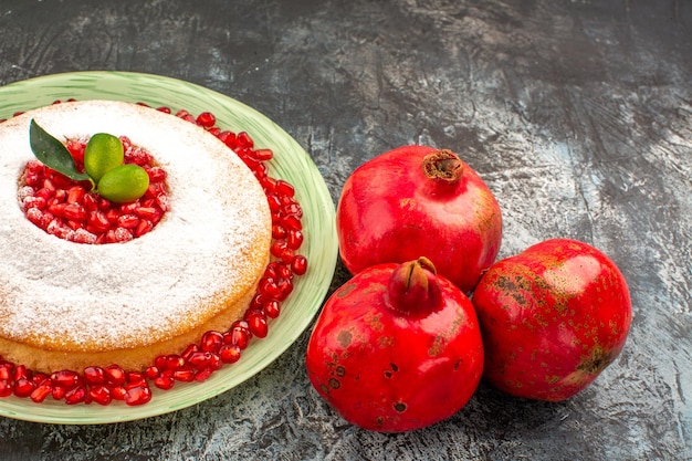 Seitennahaufnahme ein appetitlicher Kuchen ein appetitlicher Kuchen mit Zitrusfrüchten und drei Granatäpfeln