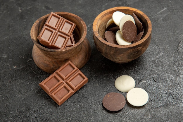 Seitennahaufnahme-Schokoladenschalen einer appetitlichen Schokolade auf dem dunklen Tisch