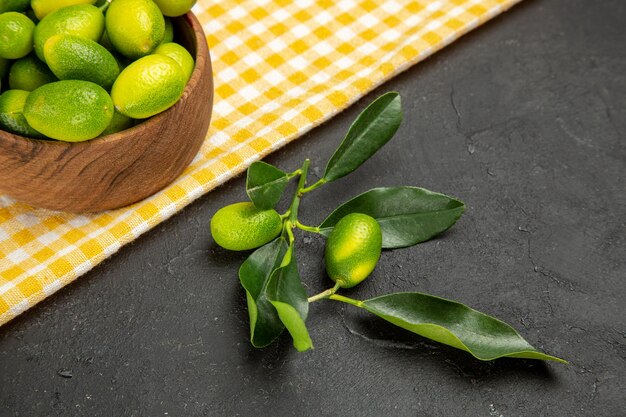 Seitennahaufnahme Zitrusfrüchte Früchte in der Schüssel auf der weiß-gelben Tischdecke