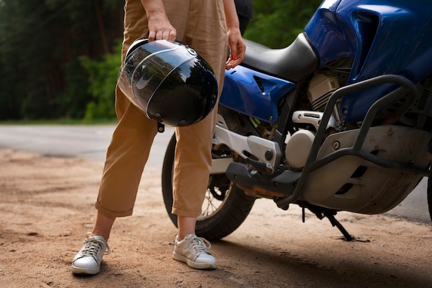 Kostenloses Foto seitliche ansicht coole alte frau mit motorrad