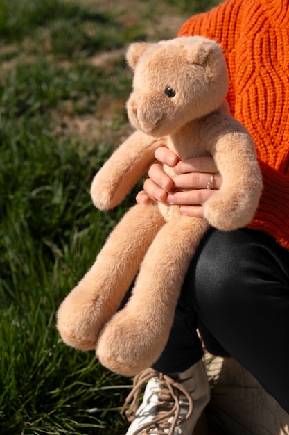 Kostenloses Foto seitliche ansicht kind hält teddybär im freien