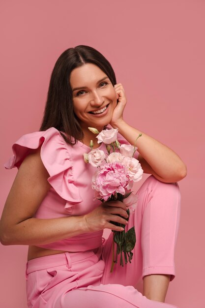 Seitliche Ansicht von einer Frau, die mit einem rosa Outfit posiert