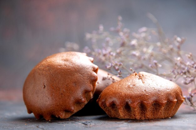 Seitliche Nahaufnahme leckere Cupcakes die appetitlichen Cupcakes auf dem Tisch neben den Zweigen