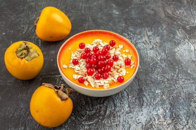 Seitliche Nahaufnahmebeerenbeeren drei appetitliche Kaki-Beeren in der Orangenschale