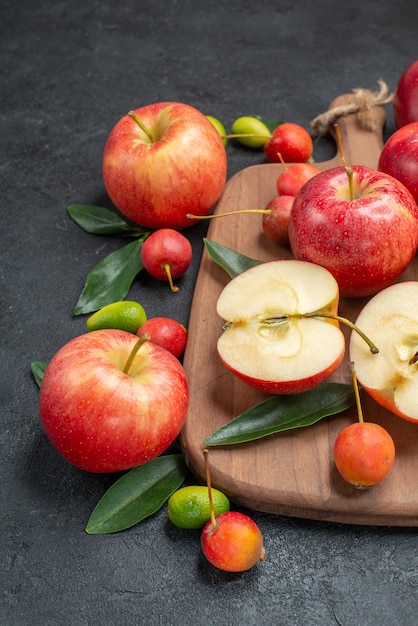 Seitliche Nahaufnahmefruchtfrüchte-Fruchtbeeren mit Blättern auf dem Brett neben den Früchten