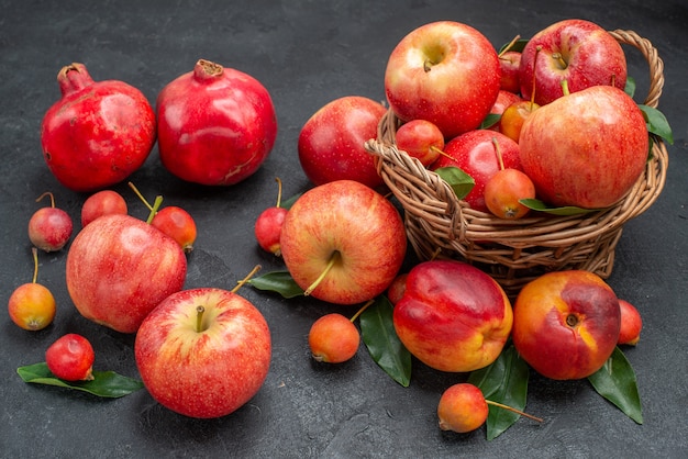 Seitliche Nahaufnahmefrüchte Früchte der hölzerne Korb der Apfelkirschen verlässt Nektarinengranatäpfel