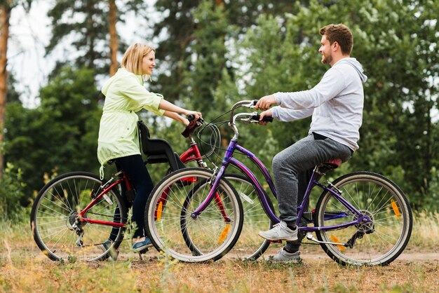 Seitwärts glückliches Paar auf Fahrrädern