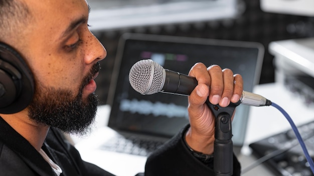 Kostenloses Foto seitwärts junger mann, der an einem radiosender arbeitet