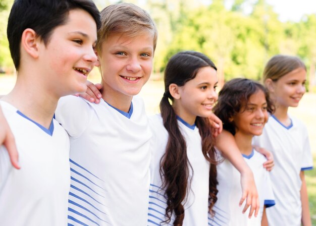 Seitwärts Kinder in Sportbekleidung halten sich gegenseitig