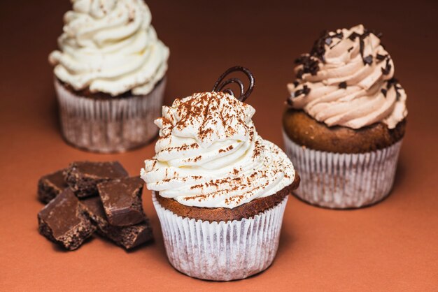 Selbst gemachte Muffins mit wirbelter Sahnehäubchen